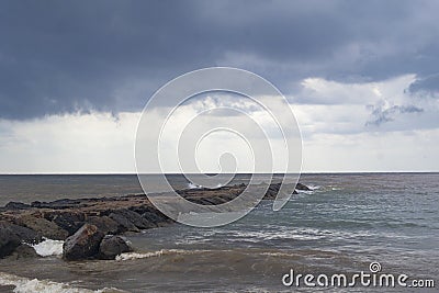 The beach of BenicÃ ssim-BenicÃ¡sim and the Mediterranean Sea joining with rainwater and floods producing a mixture of sediments l Stock Photo